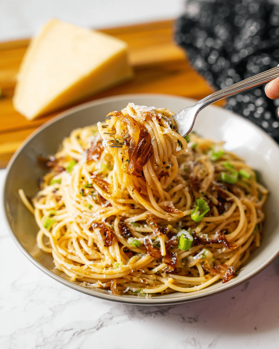 A plate of spaghetti noodles sits in a white bowl on a white marbled surface, with the noodles mixed with bits of browned onions and some green onion pieces scattered on top. The noodles are coated with a light sauce that gives them a shiny appearance. A woman's hand holds a fork lifting a nest of the spaghetti, showing the mix of golden-brown onions and green onions wrapped around the noodles. In the background, there is a wedge of cheese slightly out of focus. The overall colors are warm with browns, light yellows, and fresh green accents. Photo taken with an iphone --ar 4:5 --v 7