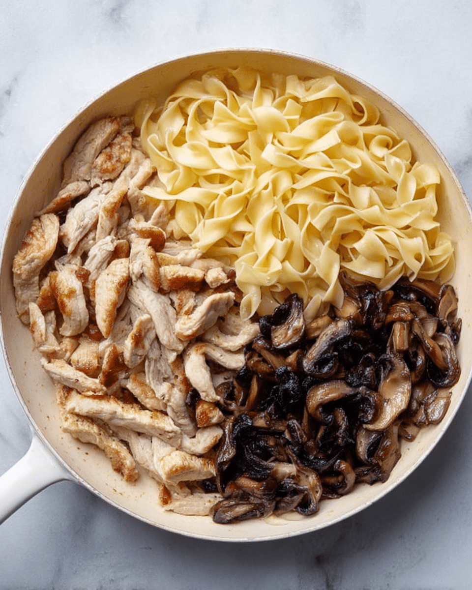 A white pan is filled with three main layers of food, each occupying a section of the pan. On the top right side, there is a pile of soft, wide, pale yellow pasta with a smooth, slightly shiny texture. On the bottom right, there is a heap of dark brown cooked mushrooms with a moist and slightly glossy look. On the left side, there are light brown cooked meat strips with a slight golden brown sear, showing a tender texture. The pan is placed on a white marbled surface. Photo taken with an iphone --ar 4:5 --v 7