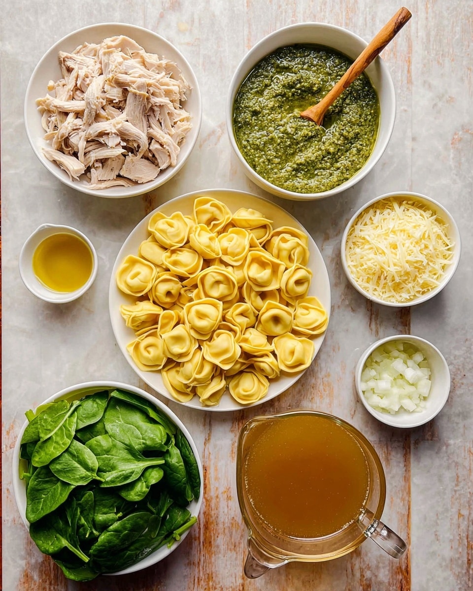 The image shows seven bowls and one pitcher arranged on a white marbled surface. In the center is a white plate filled with yellow tortellini pasta, with each piece having a folded, smooth texture and a round shape. Above and to the left is a white bowl containing shredded pale chicken, with thin, uneven strands. To its right is a white bowl holding a chunky green pesto sauce with a wooden spoon resting inside. Next to it on the right is a smaller white bowl filled with finely grated light yellow cheese, and beside it a tiny white cup with golden oil. Below the small cup is a white bowl with finely chopped white onions. At the bottom center is a clear glass measuring pitcher filled with light brown chicken broth. On the left bottom is a white bowl packed with fresh, vibrant green spinach leaves, smooth and slightly curved. The colors contrast well with the white marble background, and everything is arranged neatly. Photo taken with an iphone --ar 4:5 --v 7