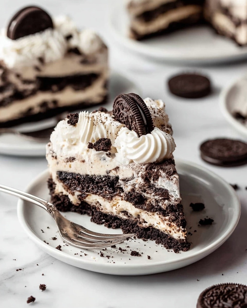 A slice of layered cookies and cream cake sits on a white plate with crumbs scattered around. The cake has three layers: a dark chocolate cookie crumb base, a middle layer of creamy white filling with swirls of crushed chocolate cookies, and a top layer of smooth white cream with visible small dark cookie bits. On top, there is a thick swirl of white whipped cream and a small dark chocolate sandwich cookie inserted at an angle. A silver fork rests on the plate beside the slice. The background shows parts of other similar slices and extra chocolate sandwich cookies scattered on a white marbled surface. Photo taken with an iphone --ar 4:5 --v 7