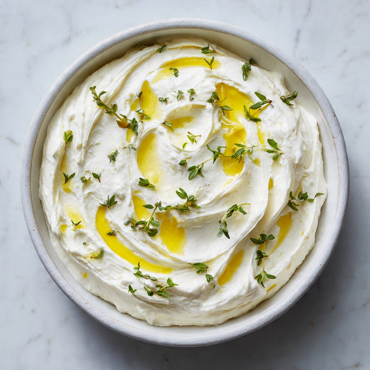 The image shows a white plate with two bagel halves topped with cream cheese, bright orange smoked salmon slices, and thin pale pink radish slices arranged neatly on top. Next to the bagels is a small white bowl filled with whipped cream cheese swirled with a drizzle of golden olive oil and garnished with fresh green thyme sprigs. Whole radishes with red skins and leafy green tops surround the plate on a white marbled surface, with a few slices of radish scattered around. The colors contrast well, creating a fresh and bright look. Photo taken with an iphone --ar 4:5 --v 7
