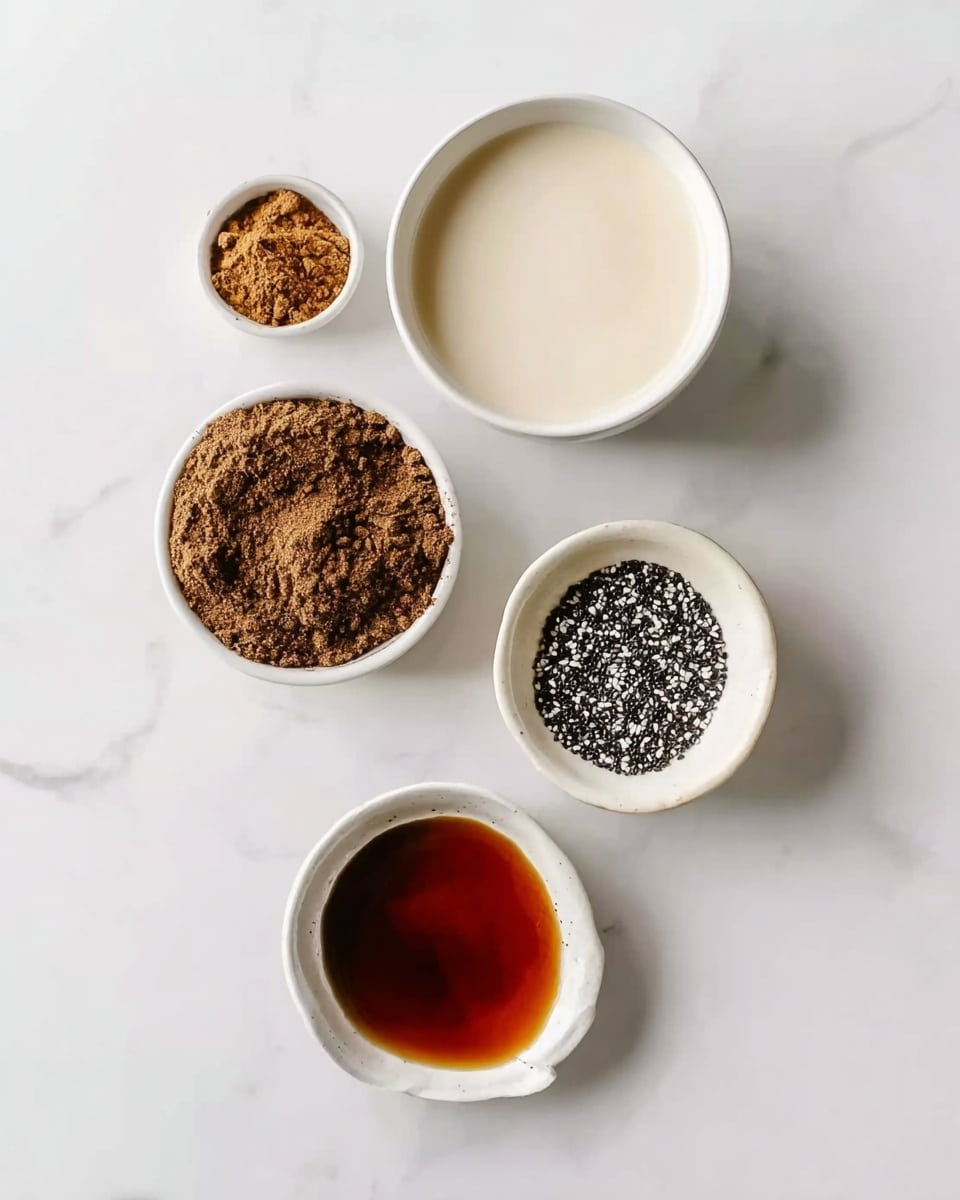 The image shows five small white bowls on a white marbled surface, each containing a different ingredient. The top bowl holds a light cream-colored liquid, smooth in texture. To the left is a bowl filled with a loose brown powder. On the right, another bowl contains small black and white seeds, finely textured. Below these, a shallow bowl with a shiny, dark reddish-brown liquid is placed above a smaller bowl filled with a thicker, darker brown liquid. The bowls are arranged in a loose diamond shape, spaced evenly. Photo taken with an iphone --ar 4:5 --v 7