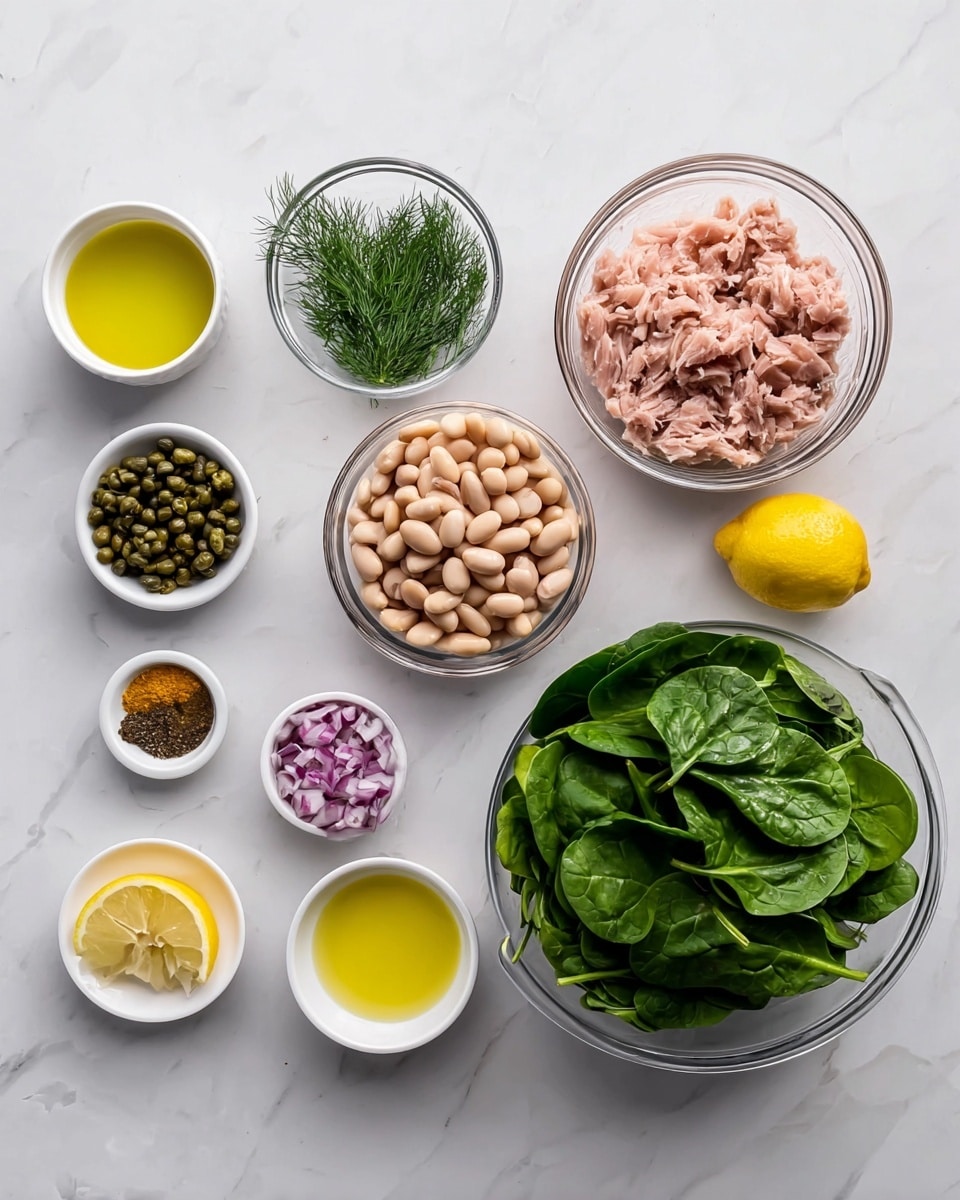 The image shows a top view of several small white bowls and two clear glass bowls arranged on a white marbled surface. The largest clear bowl at the bottom right is filled with fresh, dark green spinach leaves with a smooth texture. Next to it, a slightly smaller clear bowl contains light beige cooked beans, smooth and plump. Above that, a medium clear bowl is filled with flaked pink tuna with a soft texture. Surrounding these are small white bowls holding finely chopped purple onions, small green capers, fresh green dill, thin lemon slices, brown mustard, black pepper, salt, minced garlic, and three bowls with different yellow oils or liquid ingredients, all evenly spaced. The clean and simple arrangement highlights the fresh ingredients in bright natural lighting. photo taken with an iphone --ar 4:5 --v 7