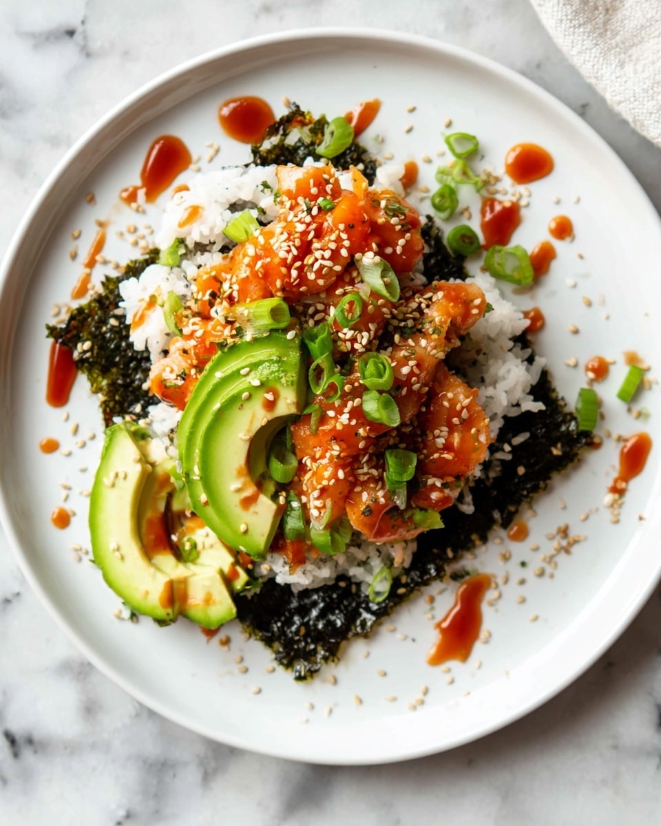 The dish shows three main layers on a white plate over a white marbled surface: a base layer of dark green seaweed sheet, a middle layer of white rice with a slightly sticky texture, and a top layer of orange spicy fish mixed with some sauce. On top of it, there are bright green slices of avocado and small chunks of green onion scattered around. White sesame seeds are sprinkled over the dish and around the plate, adding light contrast. The sauce creates shiny red streaks on the fish and avocado. The plate is simple and clean, focusing on the colorful ingredients photo taken with an iphone --ar 4:5 --v 7