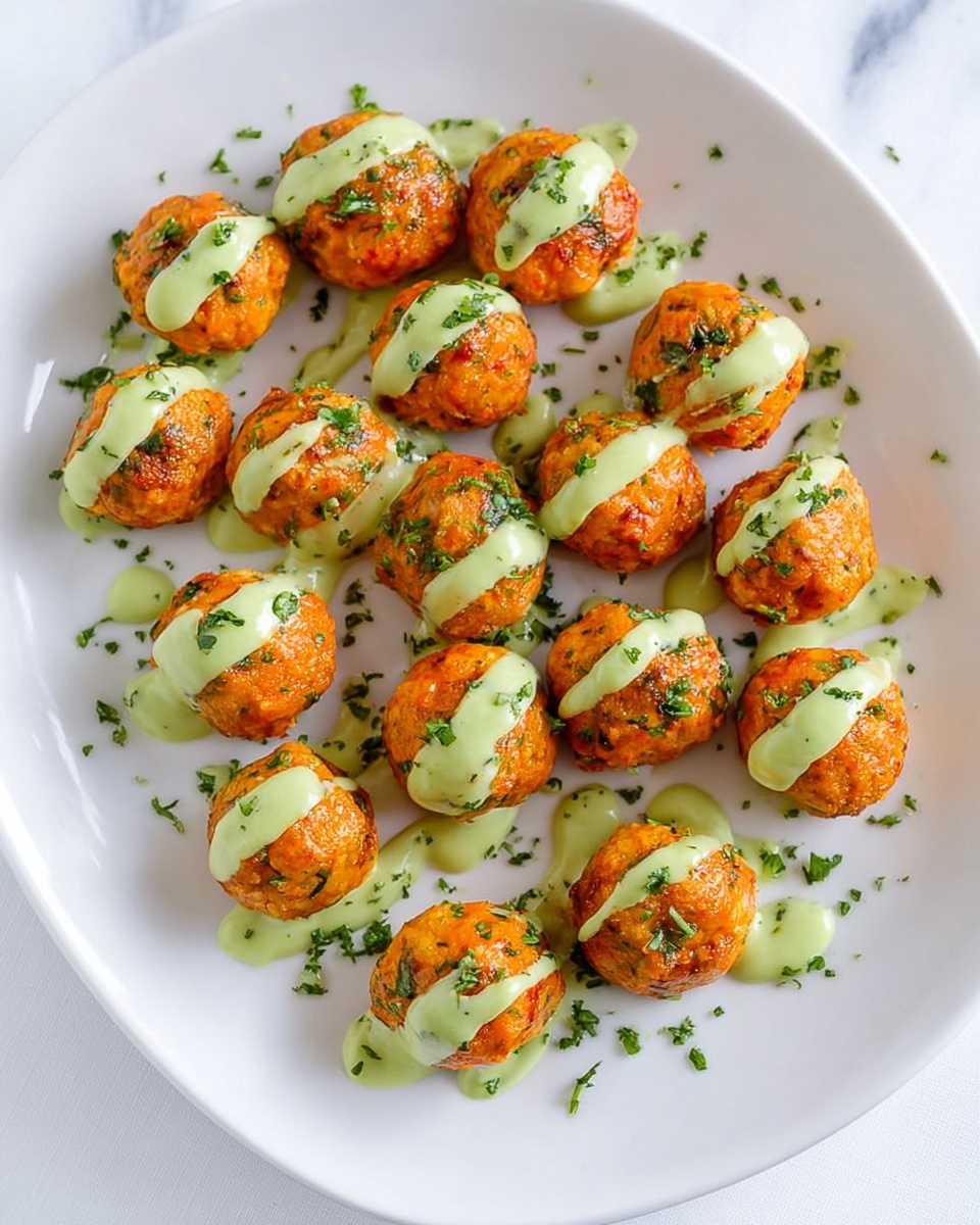 The image shows a white plate filled with evenly spaced round orange balls that look crispy on the outside and mixed with green herbs. Each ball has a smooth, light green sauce drizzled diagonally from the top left to bottom right. Around the balls, small bits of chopped green herbs are sprinkled on the plate. The background is a white marbled surface. photo taken with an iphone --ar 4:5 --v 7