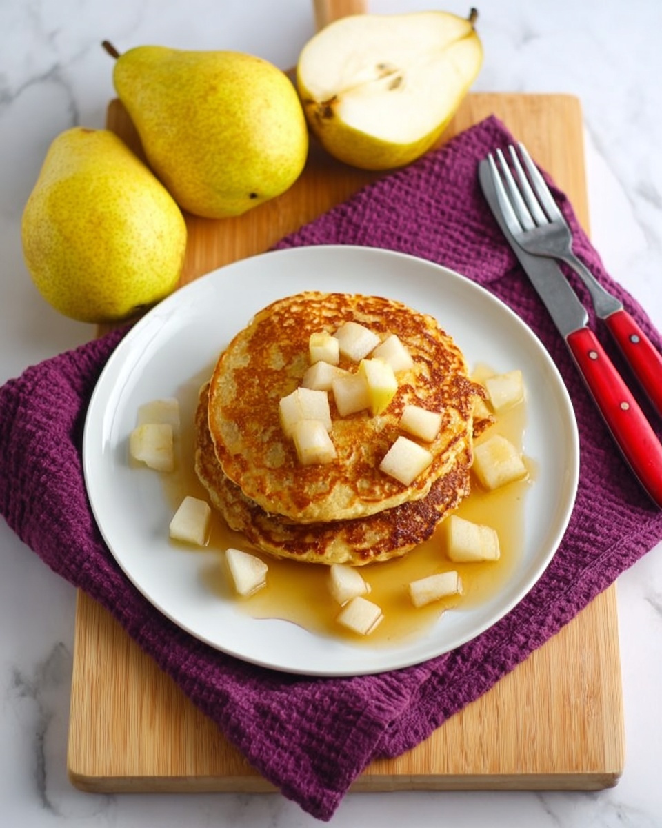 A white plate holds a stack of three golden-brown pancakes with a slightly crispy texture, topped with small, cubed white pieces of pear and drizzled with light amber syrup pooling around the base. The plate sits on a dark purple textured cloth, which is placed on a light wooden cutting board. To the left of the plate are three whole yellow pears, one cut in half showing its white interior. To the right of the plate, a fork and a knife with red handles rest on the purple cloth. The background is a white marbled surface. photo taken with an iphone --ar 4:5 --v 7