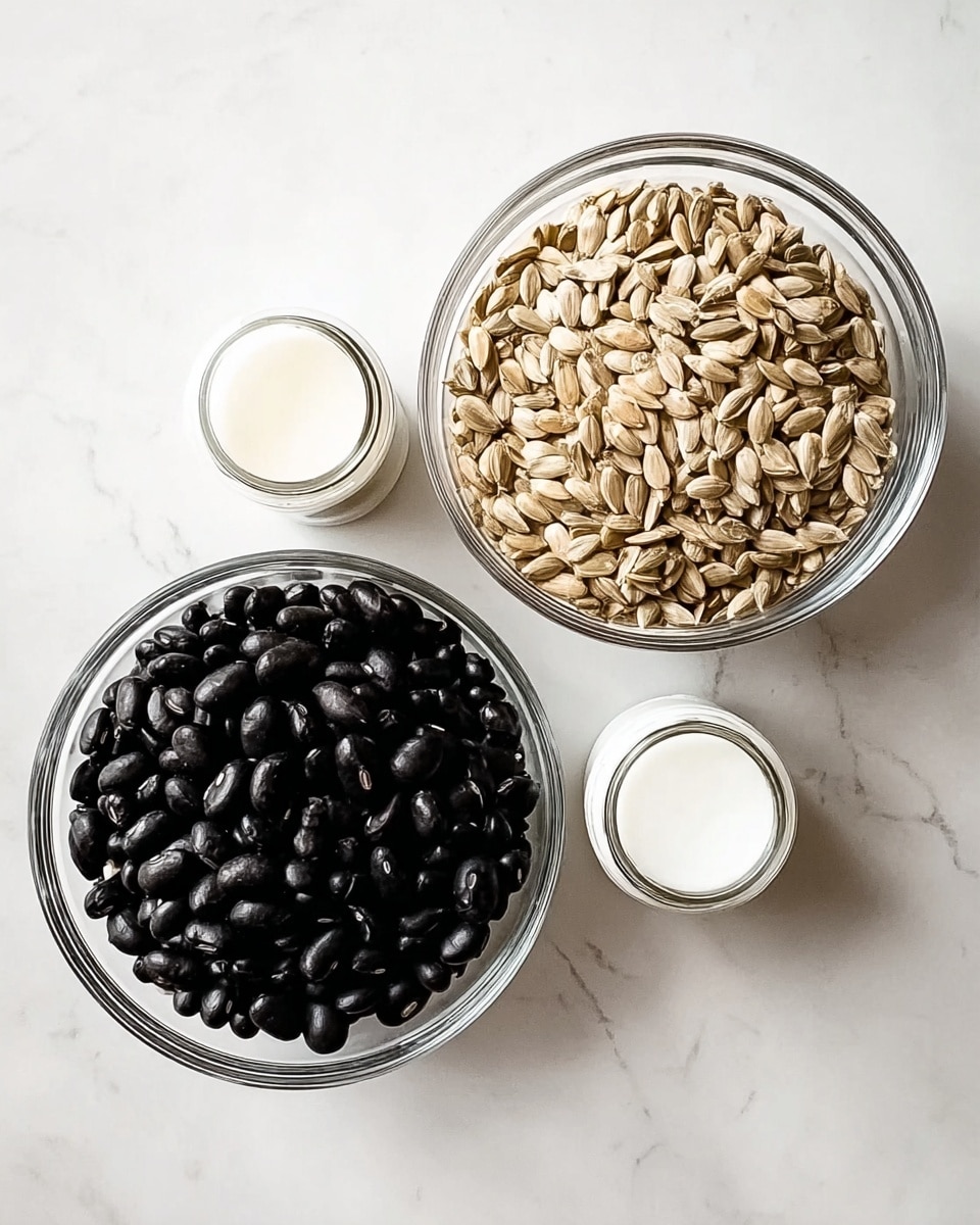 The image shows two clear glass bowls placed side by side on a white marbled surface. The bowl on the left is filled with shiny, dark black beans with a smooth texture, while the bowl on the right contains light brown sunflower seeds with a slightly rough texture. Below the bowls, there are two small white containers, likely for spices or seasoning, both with white lids. The arrangement is simple and clean, with a focus on the contrast between the dark beans and the light seeds. photo taken with an iphone --ar 4:5 --v 7