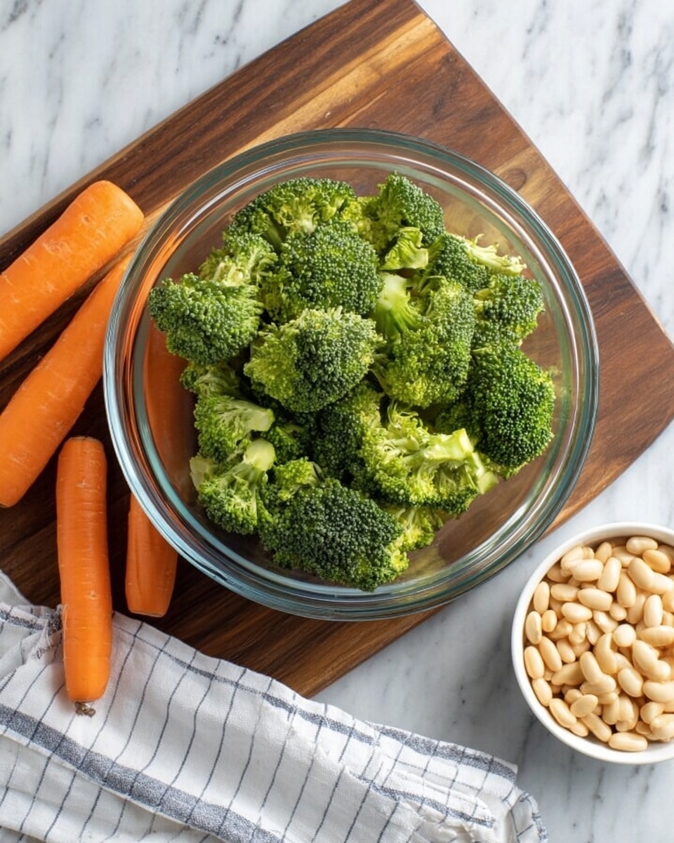A clear glass bowl filled with bright green broccoli florets sits on a dark wooden cutting board. To the left of the bowl, there are three whole orange carrots lying flat on the board. To the right, a white bowl full of pale beige beans rests partially on a white and grey striped cloth. All items are placed on a white marbled surface. Photo taken with an iphone --ar 4:5 --v 7