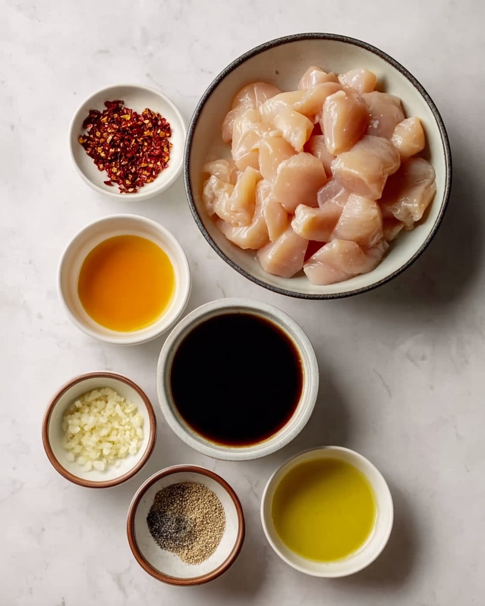 The image shows seven bowls arranged neatly on a white marbled surface. The largest bowl at the top is filled with raw, small pieces of pale pink chicken, smooth and moist in texture. Below it, in a white bowl with a dark rim, there is a thick, glossy, dark soy sauce. To the left of the soy sauce is a small white bowl filled with tiny red chili flakes. Next to it, on the left, is a white bowl containing a clear, bright orange liquid, likely a sauce or oil. Below these bowls are three smaller ones: one with minced garlic in a brown bowl, one with a mix of white salt and black pepper in a tiny white bowl, and lastly, a white bowl with a golden yellow oil. Everything is arranged for easy visibility with soft, natural lighting. photo taken with an iphone --ar 4:5 --v 7