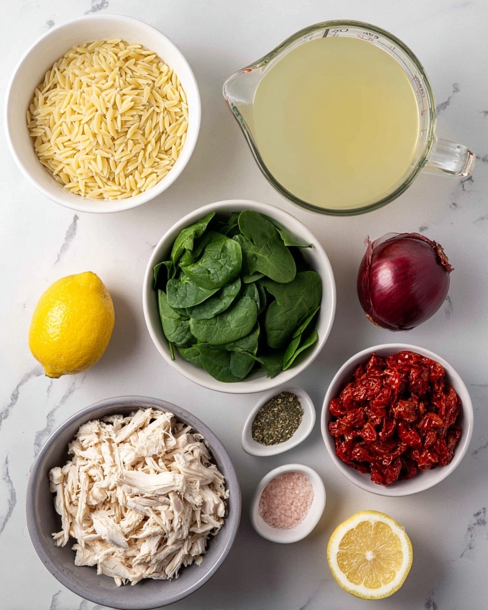 The image shows several white bowls and items arranged on a white marbled surface. There is a white bowl filled with light yellow orzo pasta, a white bowl with fresh green spinach leaves, a white bowl holding bright red sun-dried tomatoes, and a white bowl containing crumbly white cheese. A larger gray bowl holds shredded light beige chicken. On the surface near the bowls, there are three garlic cloves, a deep red onion, a whole bright yellow lemon, and a small white dish with pink salt and dried green herbs side by side. A large glass measuring cup filled with pale yellow liquid broth is also present. The setup is neat and colorful, showing all ingredients clearly. photo taken with an iphone --ar 4:5 --v 7