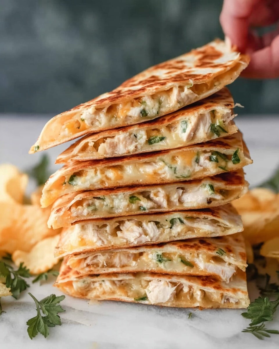 The image shows a tall stack of six folded quesadilla halves, each layer revealing a warm, golden-brown tortilla with melted cheese and small pieces of white chicken mixed with green herbs inside. The quesadillas are neatly piled on top of each other, creating a visually appealing, slightly uneven tower with the layers clearly visible from the side. The background is a white marbled texture, and delicate green leaves along with pale yellow potato chips are scattered at the base of the stack. A woman's hand reaches from the side, about to pick one. Photo taken with an iphone --ar 4:5 --v 7